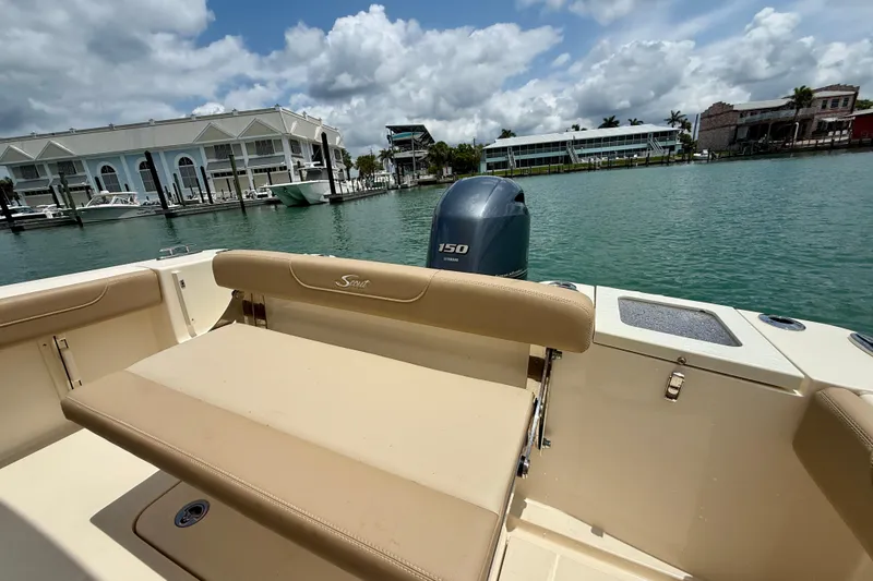 Slide: The Image of 2023 Scout 215 XSF boat with Yamaha 150 engine, docked near waterfront buildings. - 20