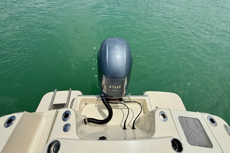 Slide: The Image of 2023 Scout 215 XSF boat with 150 HP outboard motor on turquoise water. - 25