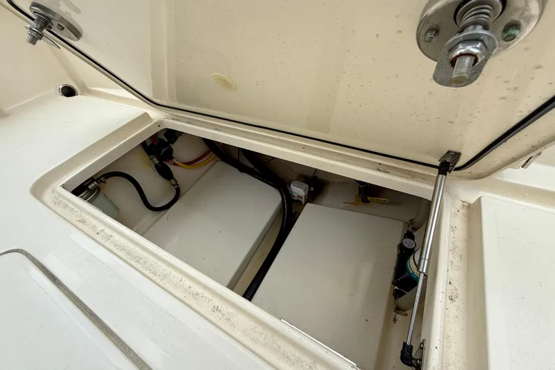 Slide: The Image of Open storage compartment of 2023 Scout 215 XSF boat, showing internal components and wiring. - 29