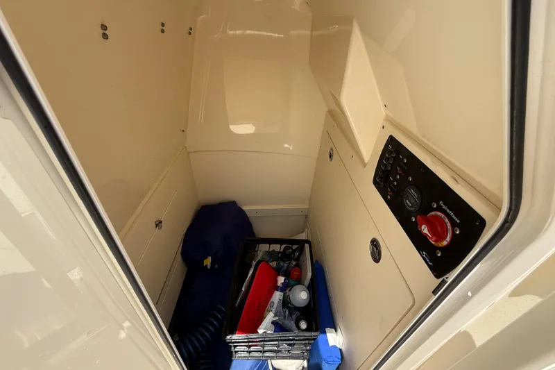 Slide: The Image of 2023 Scout 215 XSF boat storage compartment with control panel and supplies. - 30