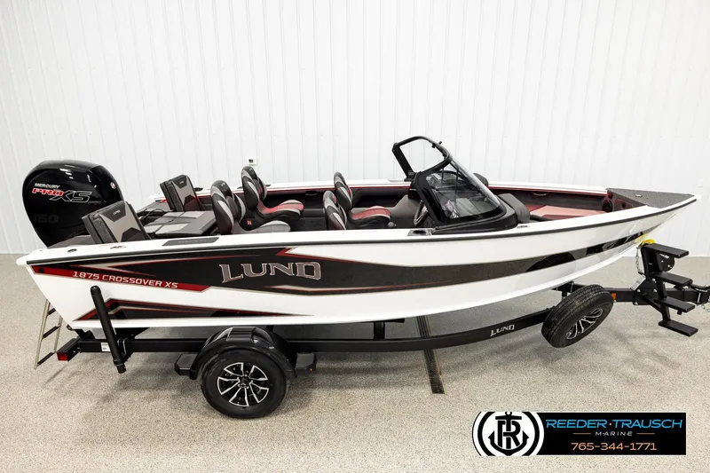 The Image of 2026 Lund 1875 Crossover XS boat on trailer, featuring sleek design and Mercury Pro XS engine. - 1