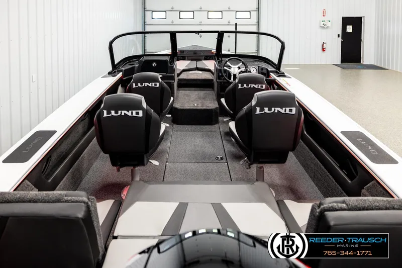 Slide: The Image of 2026 Lund 1875 Crossover XS boat interior with branded seats in showroom. - 11