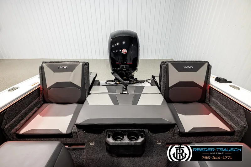 Slide: The Image of 2026 Lund 1875 Crossover XS boat interior with seating and motor, showcased by Reeder-Trausch Marine. - 16