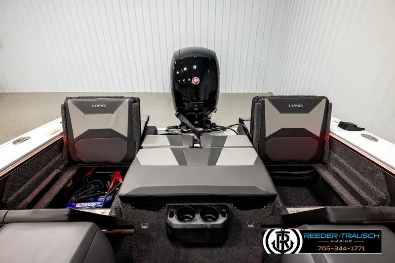 Slide: The Image of 2026 Lund 1875 Crossover XS boat interior with seating and motor, showcased by Reeder-Trausch Marine. - 17