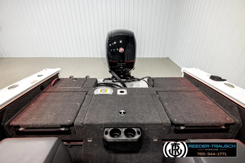 Slide: The Image of 2026 Lund 1875 Crossover XS boat interior with motor, carpeted deck, and storage compartments. - 20