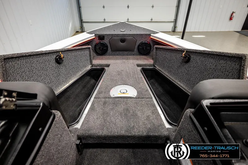 Slide: The Image of 2026 Lund 1875 Crossover XS boat interior with open storage compartments and speakers. - 27