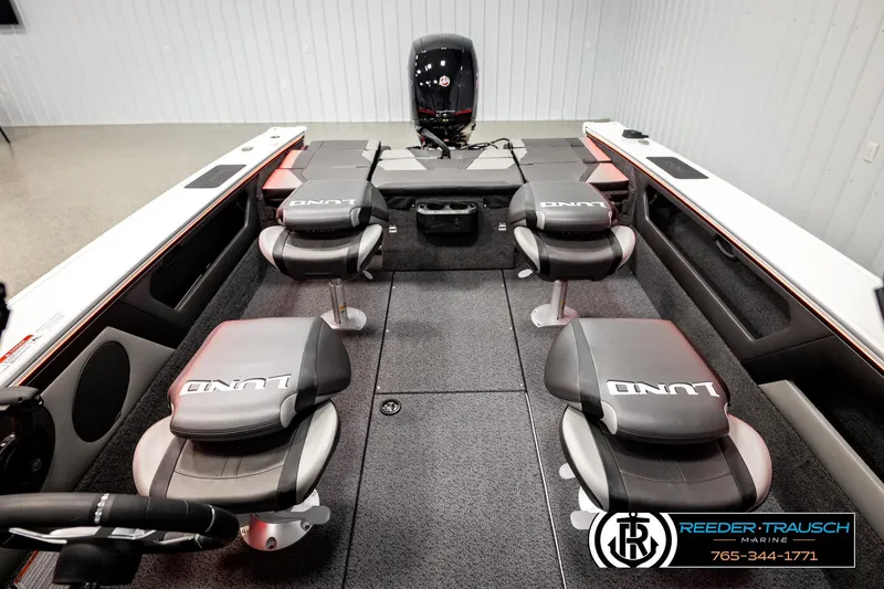 Slide: The Image of 2026 Lund 1875 Crossover XS boat interior with seating and motor, displayed at Reeder-Trausch Marine. - 28