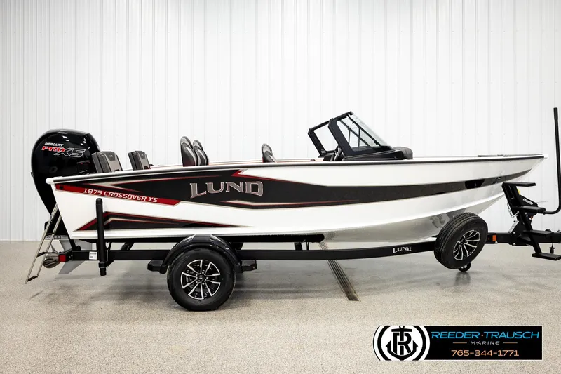 Slide: The Image of 2026 Lund 1875 Crossover XS boat on trailer, side view in showroom. - 3