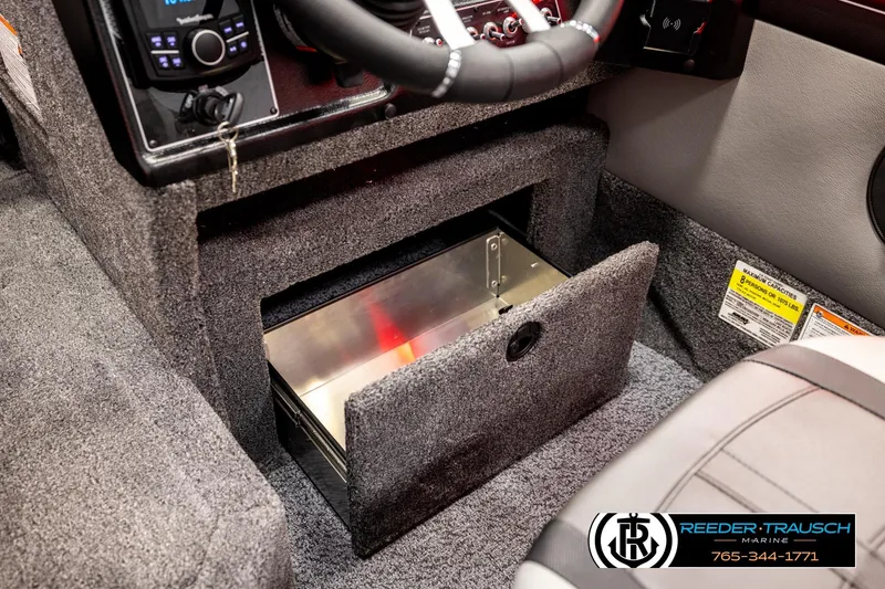 Slide: The Image of Interior of 2026 Lund 1875 Crossover XS boat showing storage compartment and control panel. - 33