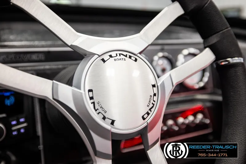 Slide: The Image of Steering wheel of 2026 Lund 1875 Crossover XS boat, featuring sleek design and branding. - 36