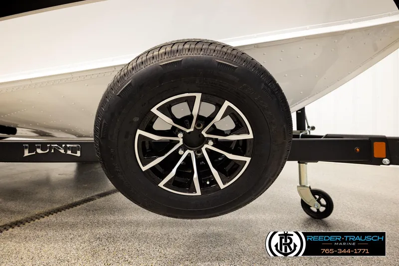 Slide: The Image of 2026 Lund 1875 Crossover XS boat trailer wheel, featuring sleek black and silver design. - 59