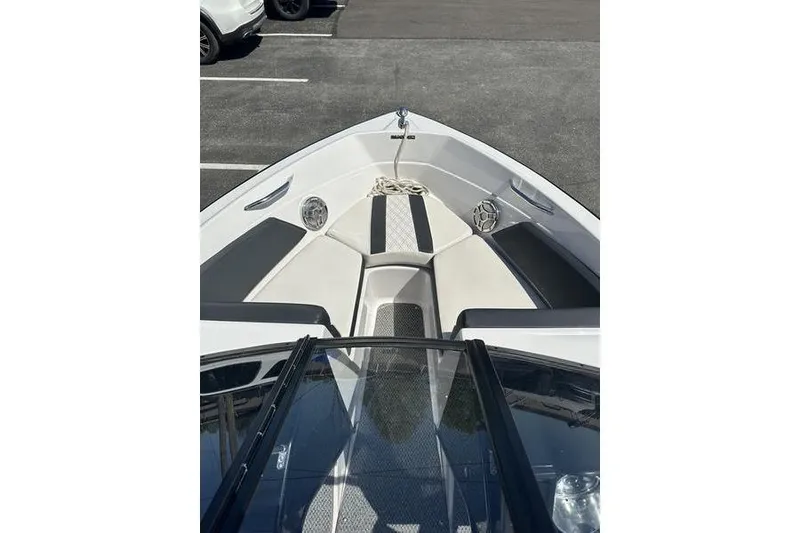Slide: The Image of 2015 Glastron GT 185 boat interior with seating and storage, parked in a lot. - 12
