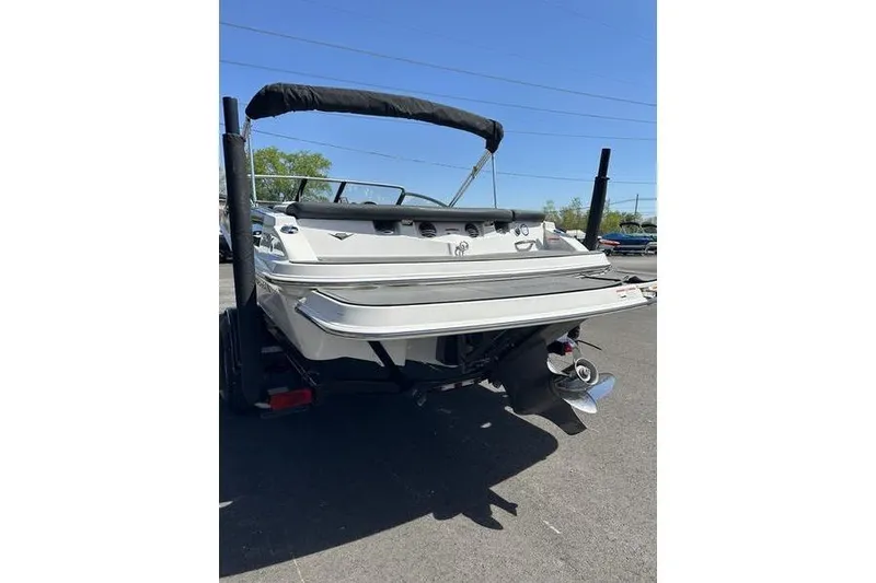 Slide: The Image of 2015 Glastron GT 185 boat, rear view, parked on asphalt under clear blue sky. - 7