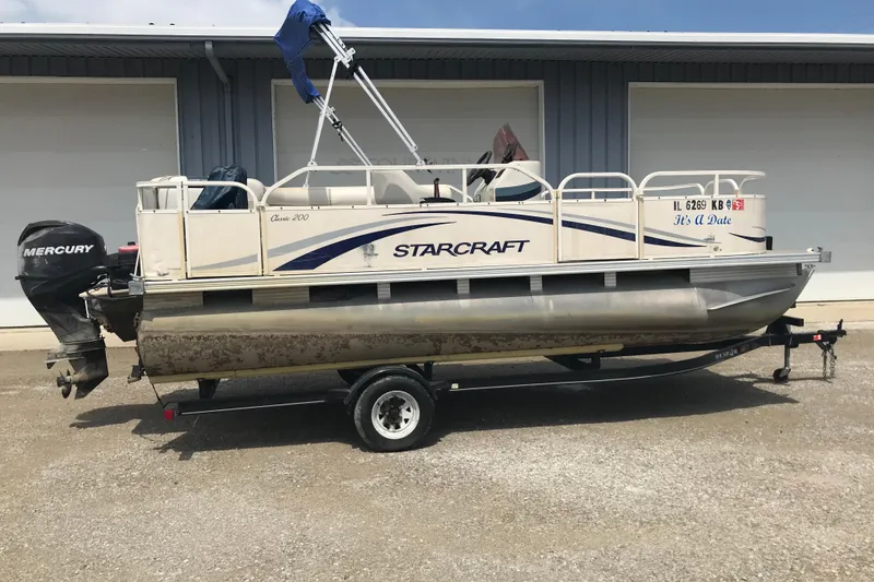 The Image of 2007 Starcraft Classic 200 CR pontoon boat on trailer with Mercury outboard motor. - 0