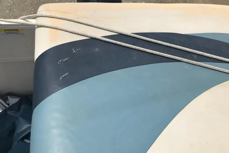 Slide: The Image of 2007 Starcraft Classic 200 CR boat seat with blue and white upholstery and visible wear. - 11