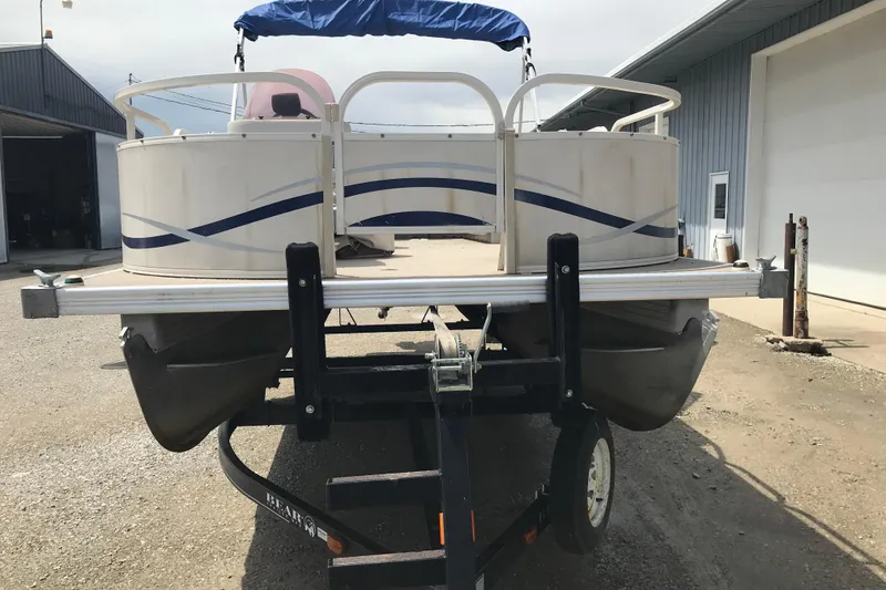 Slide: The Image of 2007 Starcraft Classic 200 CR pontoon boat on trailer, parked outside a garage. - 3
