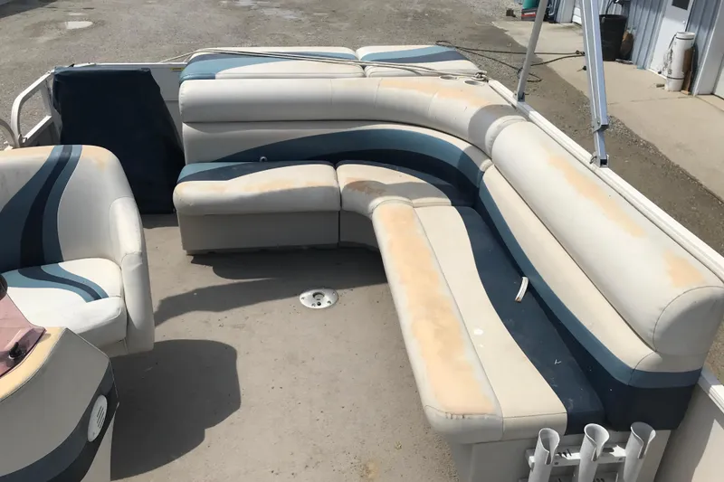 Slide: The Image of 2007 Starcraft Classic 200 CR boat interior with worn seating and blue accents. - 5