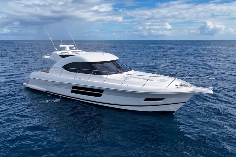 The Image of 2016 Riviera 5000 Sport Yacht cruising on open ocean under blue sky. - 1