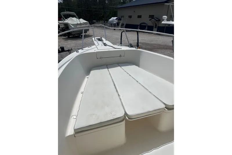Slide: The Image of 1998 Pursuit 2470 Center Console boat with spacious seating area and clean white cushions. - 11
