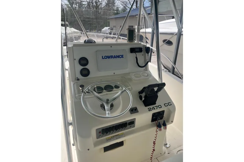 Slide: The Image of 1998 Pursuit 2470 Center Console boat dashboard with steering wheel and Lowrance navigation system. - 13