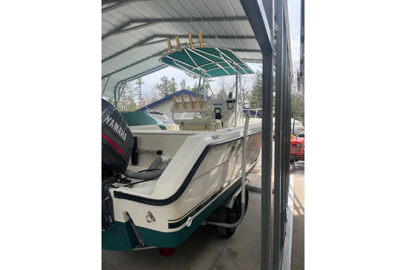 Slide: The Image of 1998 Pursuit 2470 Center Console boat with Yamaha outboard, parked under a metal canopy. - 14