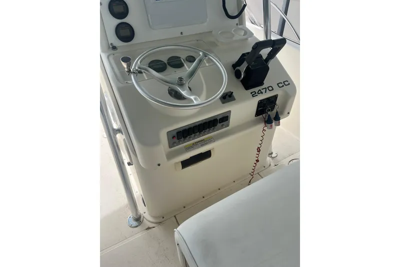 Slide: The Image of 1998 Pursuit 2470 Center Console boat dashboard with steering wheel and controls. - 4