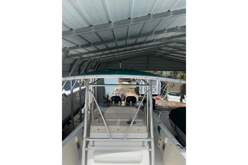Slide: The Image of 1998 Pursuit 2470 Center Console boat under metal shelter, rear view. - 9