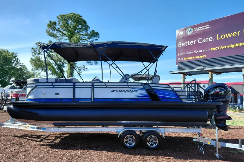 Slide: The Image of 2026 Starcraft SLS 3 Q DH pontoon boat on trailer, parked outdoors. - 2