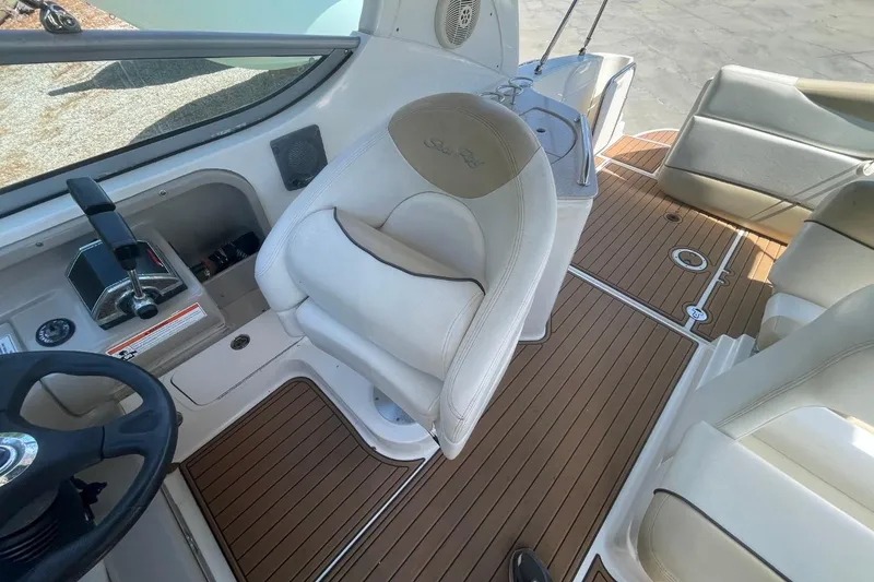 Slide: The Image of 2008 Sea Ray Sundancer 280 cockpit with beige seating and wood-style flooring. - 23