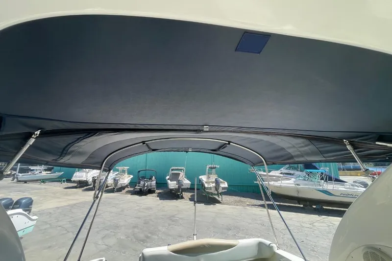 Slide: The Image of 2008 Sea Ray Sundancer 280 with bimini top, docked among other boats at a marina. - 25