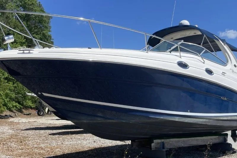 Slide: The Image of 2008 Sea Ray Sundancer 280 boat on land, blue and white hull, sunny day. - 3