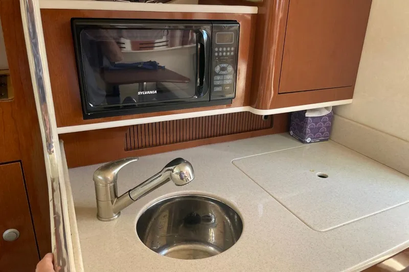 Slide: The Image of Compact kitchen area in a 2008 Sea Ray Sundancer 280 with microwave and sink. - 37