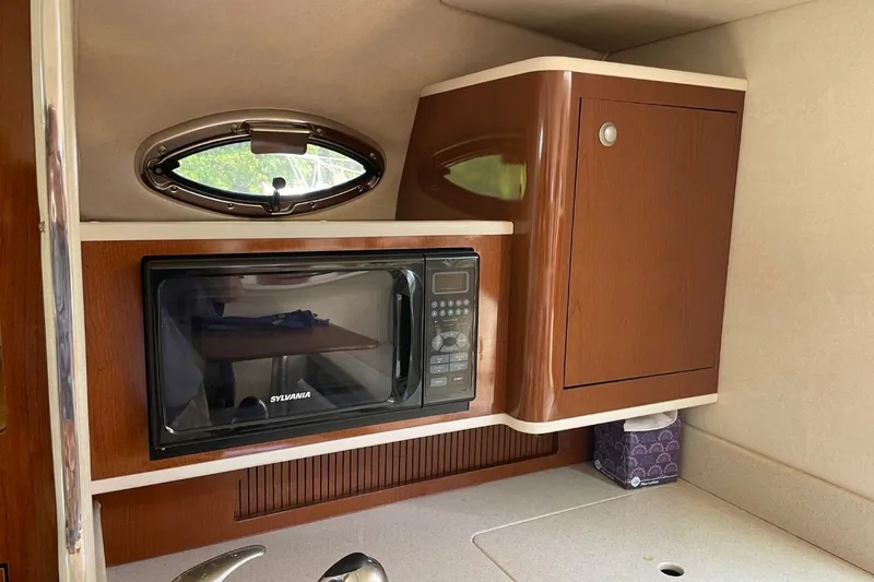 Slide: The Image of 2008 Sea Ray Sundancer 280 interior with microwave and wooden cabinetry. - 38