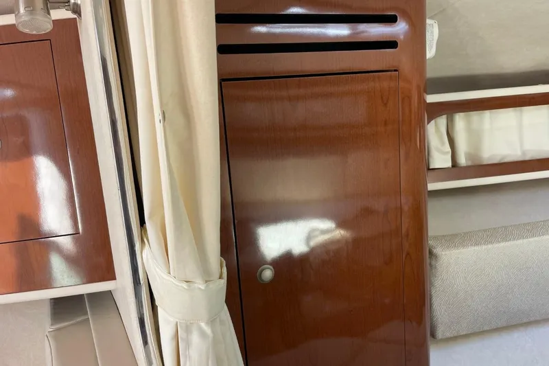 Slide: The Image of Interior of 2008 Sea Ray Sundancer 280 with polished wood cabinetry and beige curtains. - 41