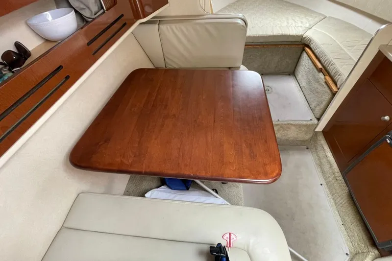 Slide: The Image of Interior of 2008 Sea Ray Sundancer 280 with wooden table and beige seating. - 51