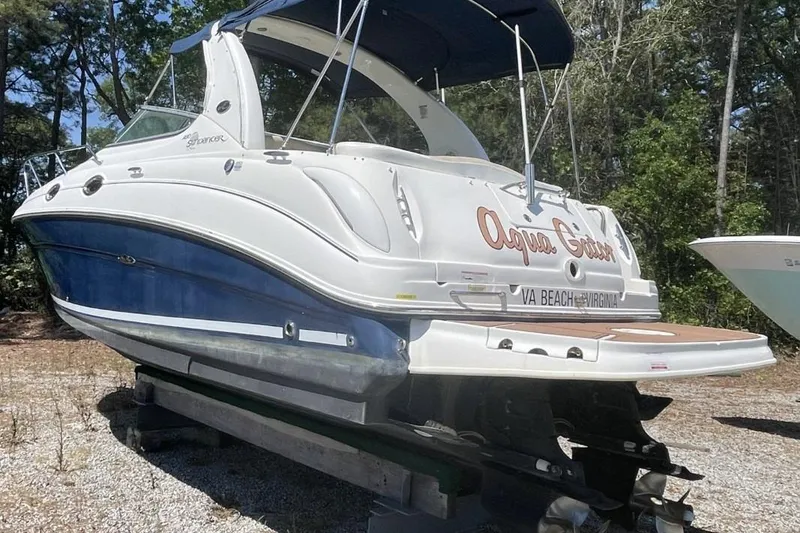 Slide: The Image of 2008 Sea Ray Sundancer 280 boat on land, featuring a blue and white exterior. - 6