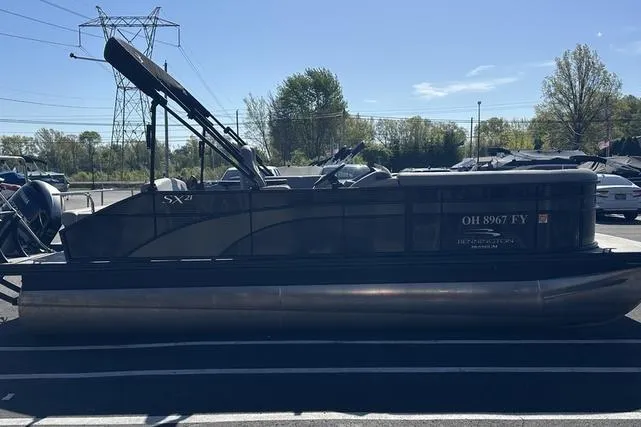 Slide: The Image of 2020 Bennington 21 SSBXP pontoon boat parked in a lot under clear skies. - 4