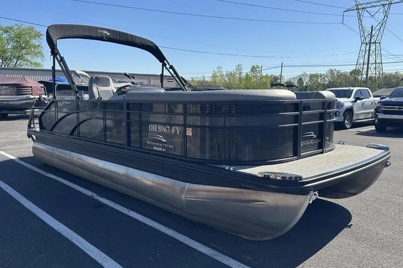 Slide: The Image of 2020 Bennington 21 SSBXP pontoon boat parked in a lot under clear skies. - 5