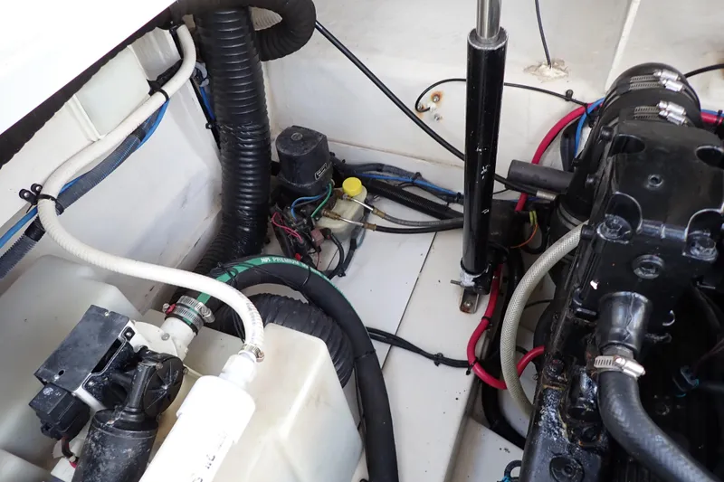 Slide: The Image of Engine compartment of a 2005 Sea Ray Sundancer 260 with visible hoses and components. - 103