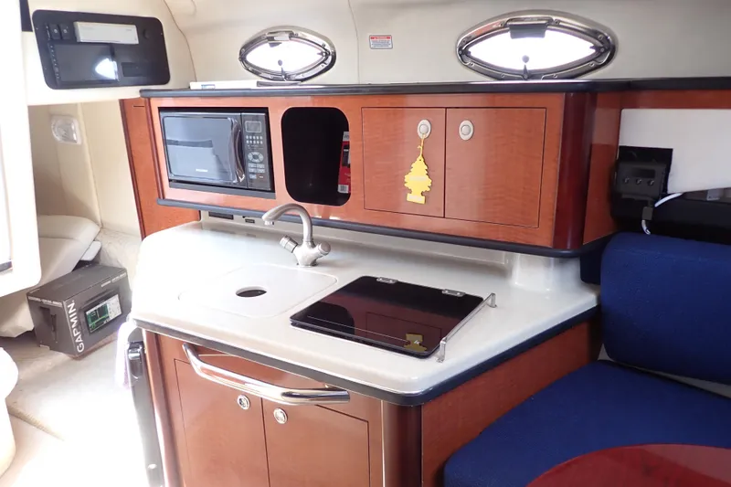 Slide: The Image of 2005 Sea Ray Sundancer 260 interior with kitchenette, microwave, and sink. - 11