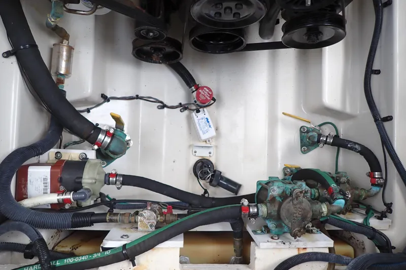 Slide: The Image of Engine compartment of a 2005 Sea Ray Sundancer 260, showcasing hoses and mechanical components. - 116