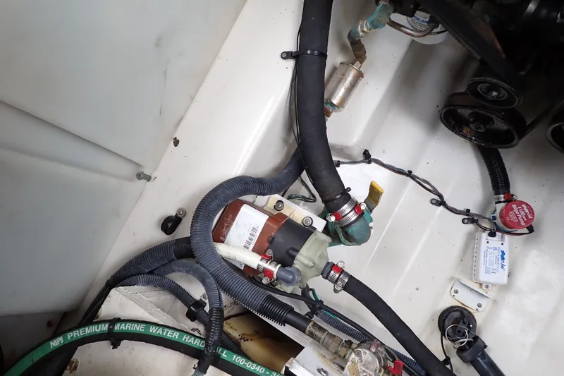 Slide: The Image of Engine compartment of a 2005 Sea Ray Sundancer 260, showcasing hoses and mechanical components. - 117