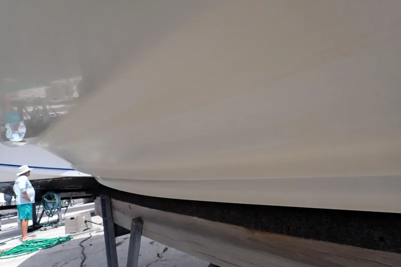Slide: The Image of 2005 Sea Ray Sundancer 260 boat hull on dry dock, with person nearby. - 126