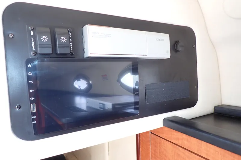 Slide: The Image of Control panel inside 2005 Sea Ray Sundancer 260 boat, featuring switches and a Clarion unit. - 17