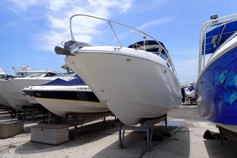 Slide: The Image of 2005 Sea Ray Sundancer 260 boat on dry dock under clear blue sky. - 2