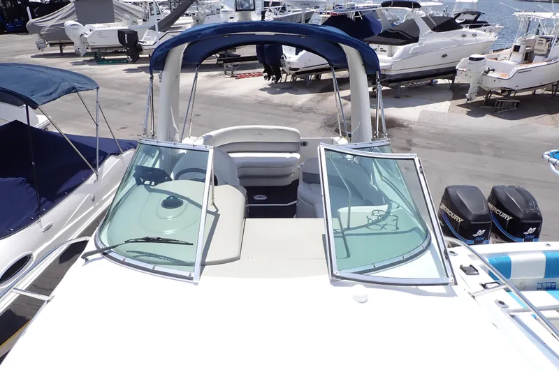 Slide: The Image of 2005 Sea Ray Sundancer 260 boat with open windshield, docked at marina. - 25