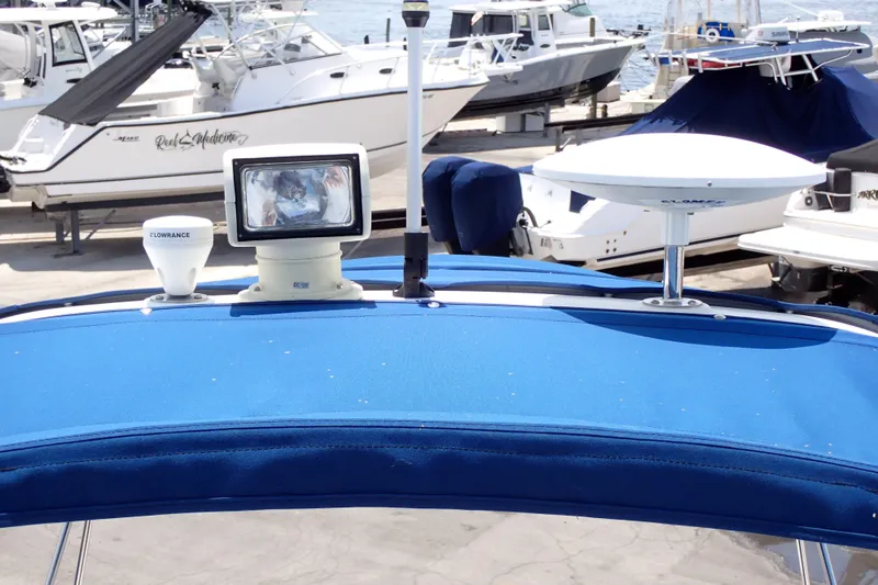 Slide: The Image of 2005 Sea Ray Sundancer 260 with blue canopy and marine electronics at dock. - 26
