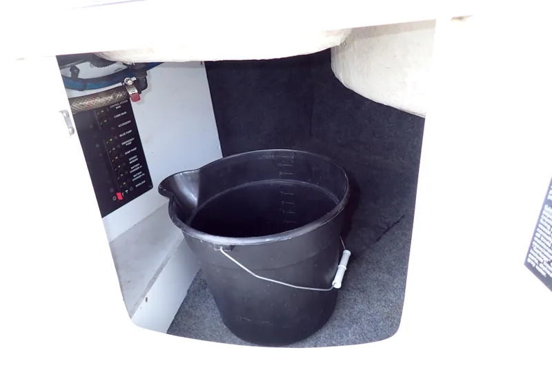 Slide: The Image of 2005 Sea Ray Sundancer 260 interior storage with black bucket and control panel. - 36
