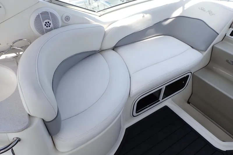 Slide: The Image of 2005 Sea Ray Sundancer 260 interior seating with white upholstery and integrated speaker. - 40
