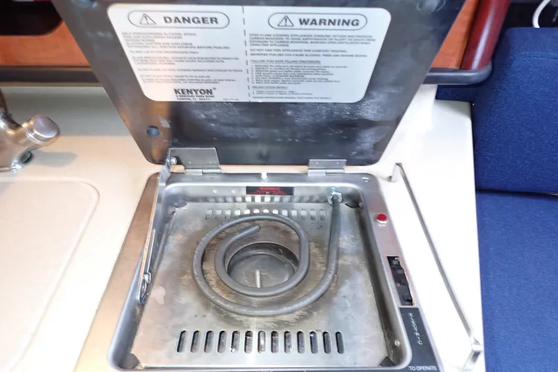 Slide: The Image of Electric stove on 2005 Sea Ray Sundancer 260 boat, featuring safety warnings and coiled heating element. - 58